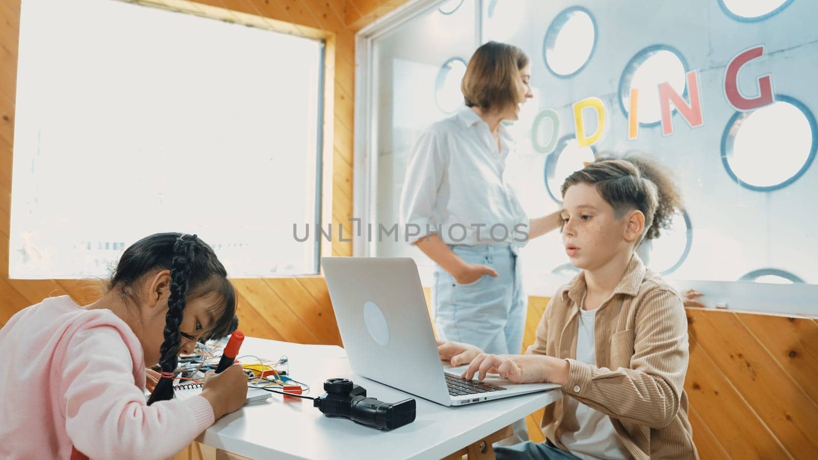 Smart teacher teaching and looking student using laptop at classroom. Professional instructor explained about programing engineering code or prompt while studying and learning program. Erudition.