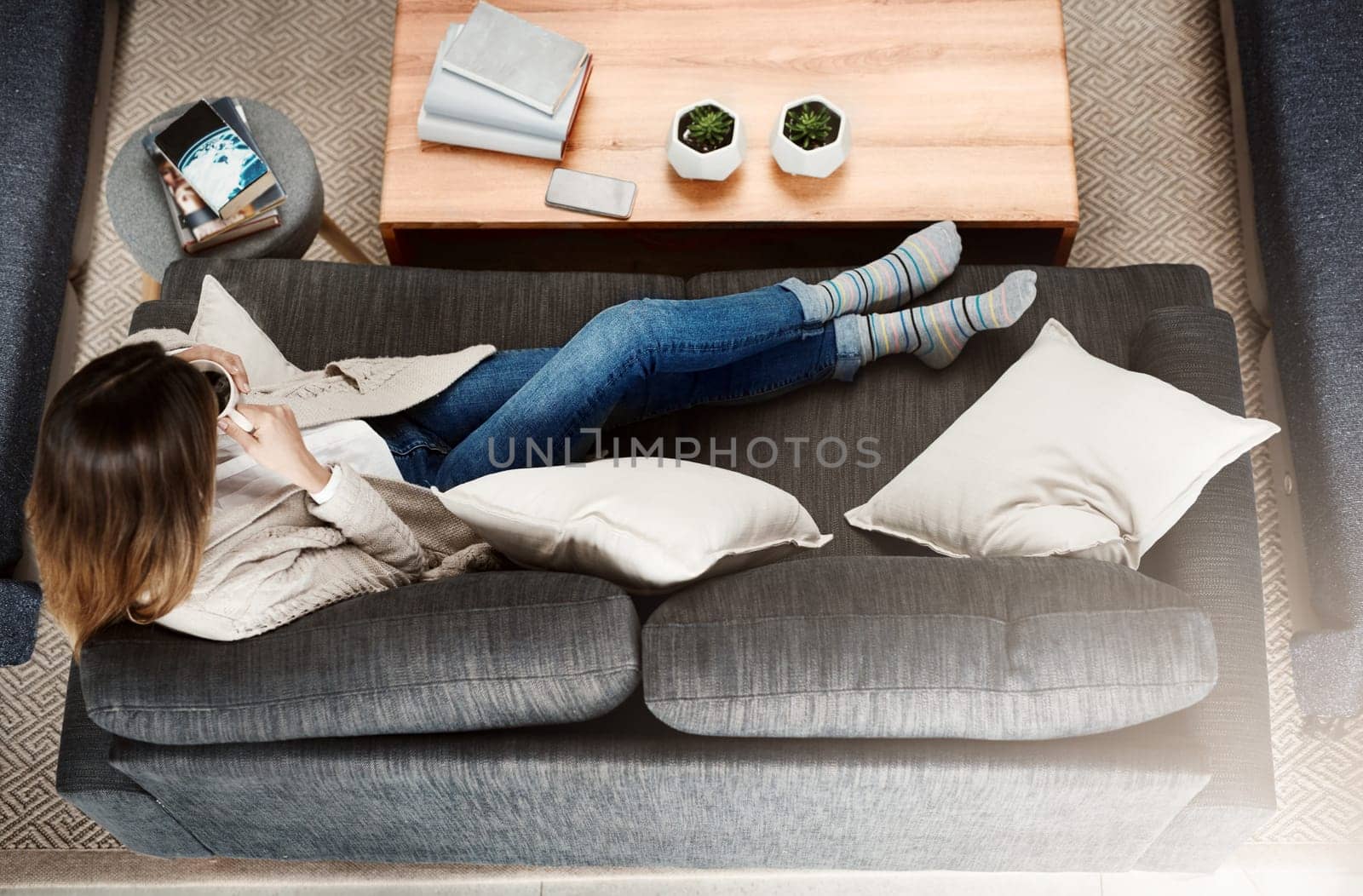 Woman, relax and sofa with coffee as top view in home living room or morning beverage, peaceful or calm. Female person, couch and comfortable in apartment or from above in lounge, day off or rest by YuriArcurs