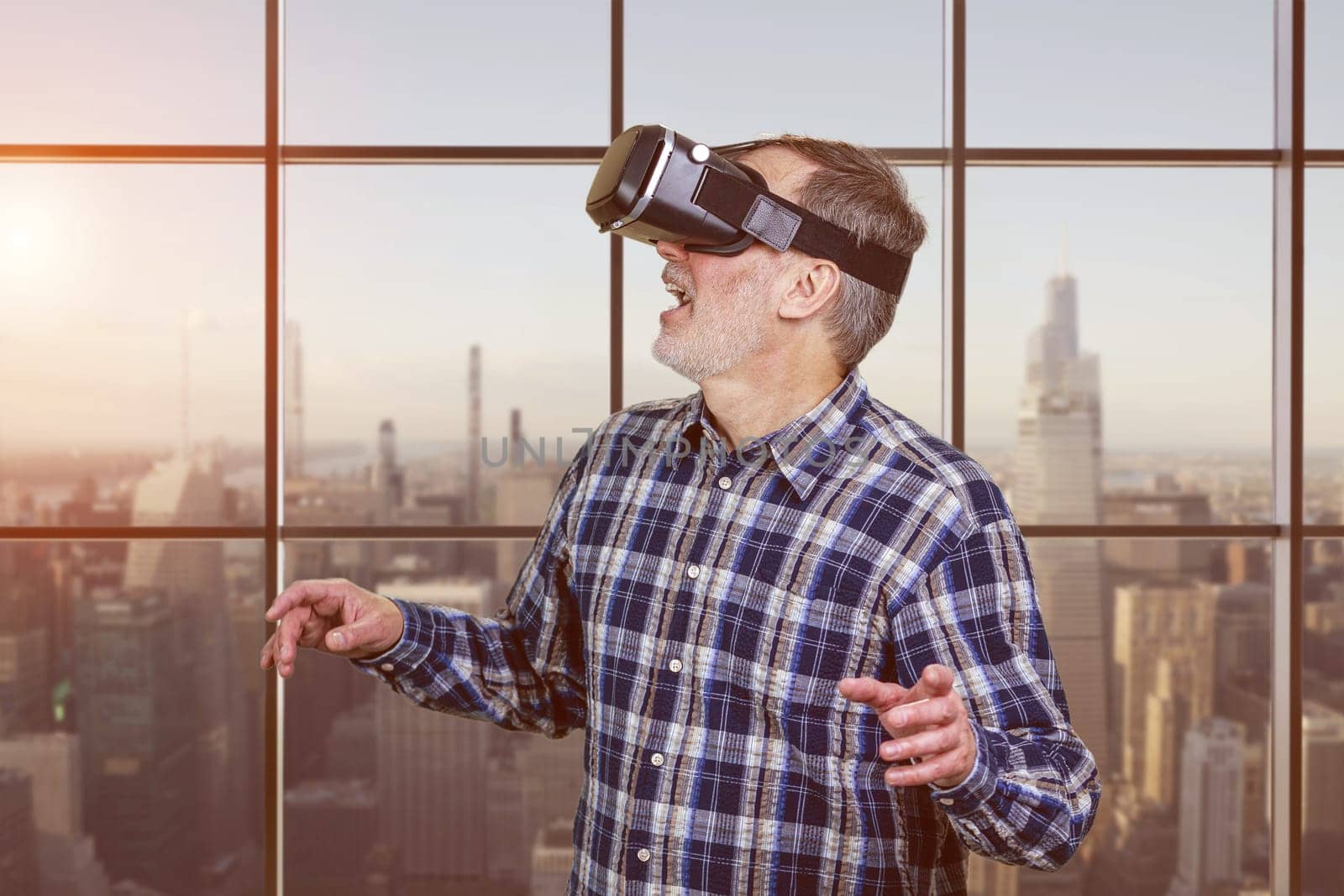 Portrait of excited elder man in vr headset. Checkered window background.