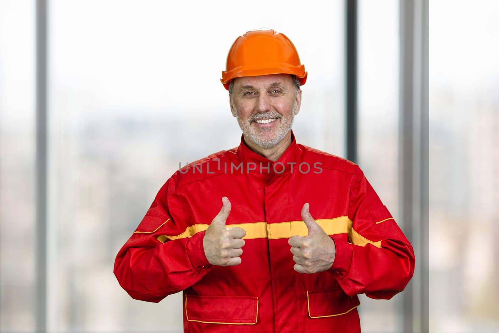 Portrait of a smiling handyman construction worker showing both thumb up. by super_picture