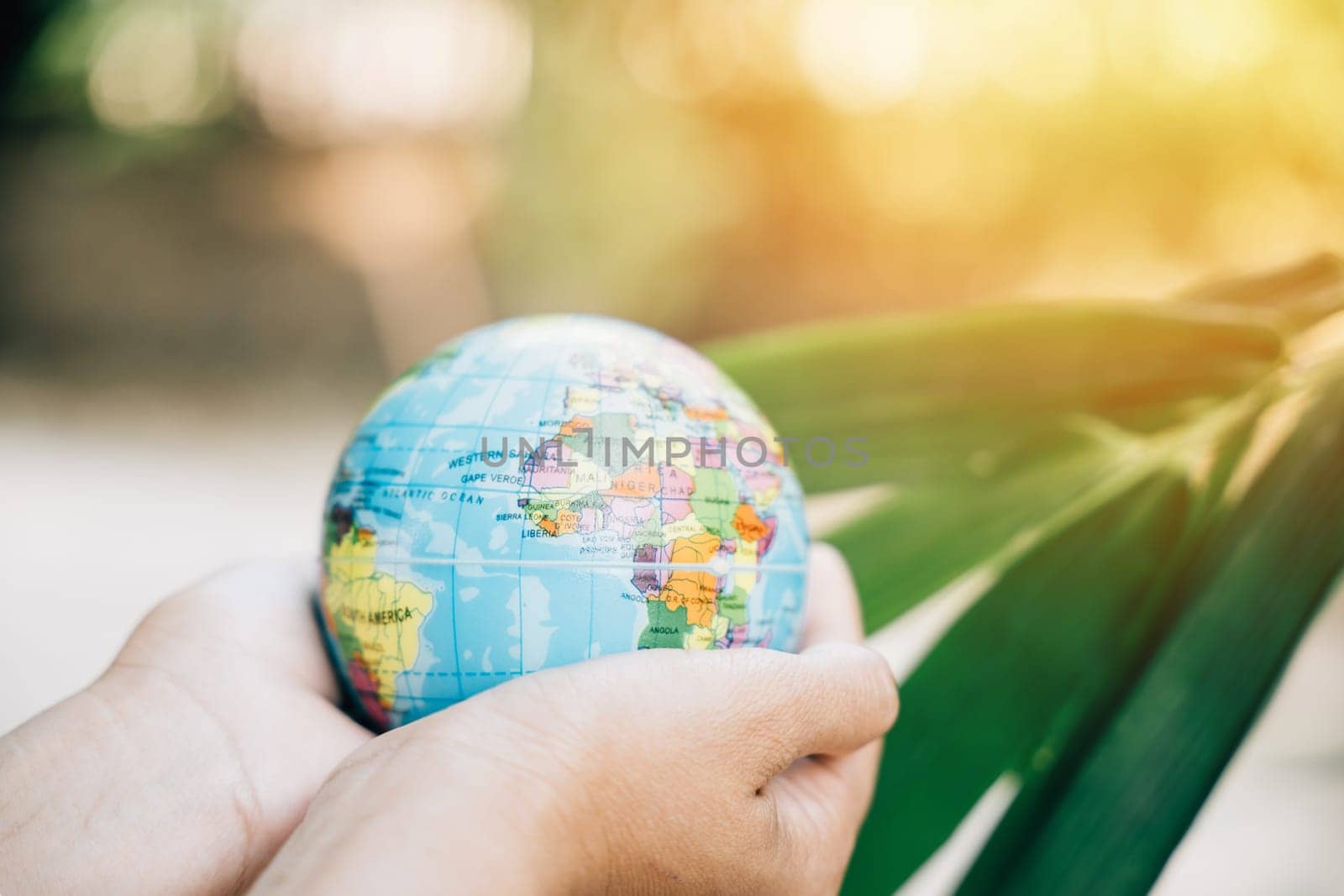 In this Environment and Earth Day concept, hold the Green Planet in Your Hands as a symbol of responsibility, support, and wisdom for our environment. Let's save Earth together by Sorapop
