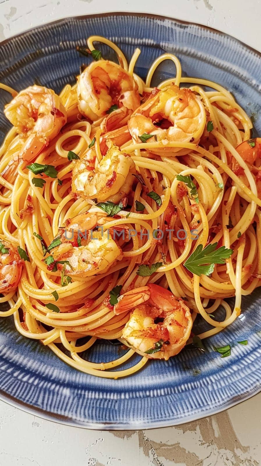 Pasta with shrimps, tomatoes and basil on a plate by Anneleven