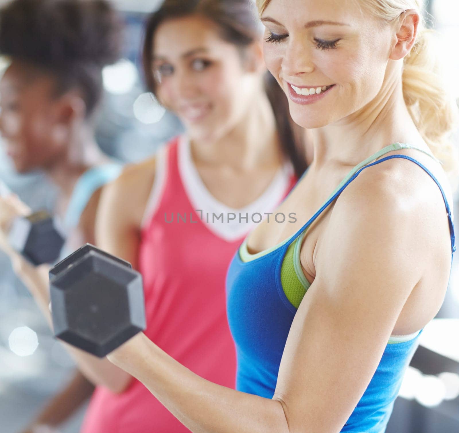 Woman, dumbbell and gym exercise or weightlifting workout for bicep growth or muscle, arms or strong. Female person, friends and fitness training for wellness goals in group class, health or smile.