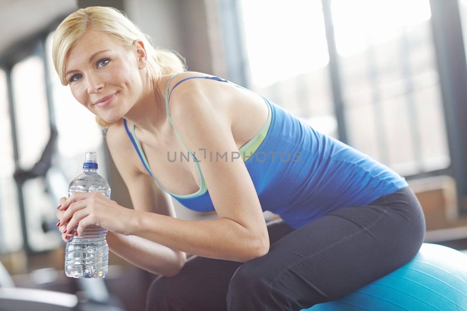 Portrait, ball or woman drinking water on break in exercise, workout or fitness training in gym. Relax, healthy girl or thirsty sports athlete with smile or bottle for wellness, rest or hydration by YuriArcurs