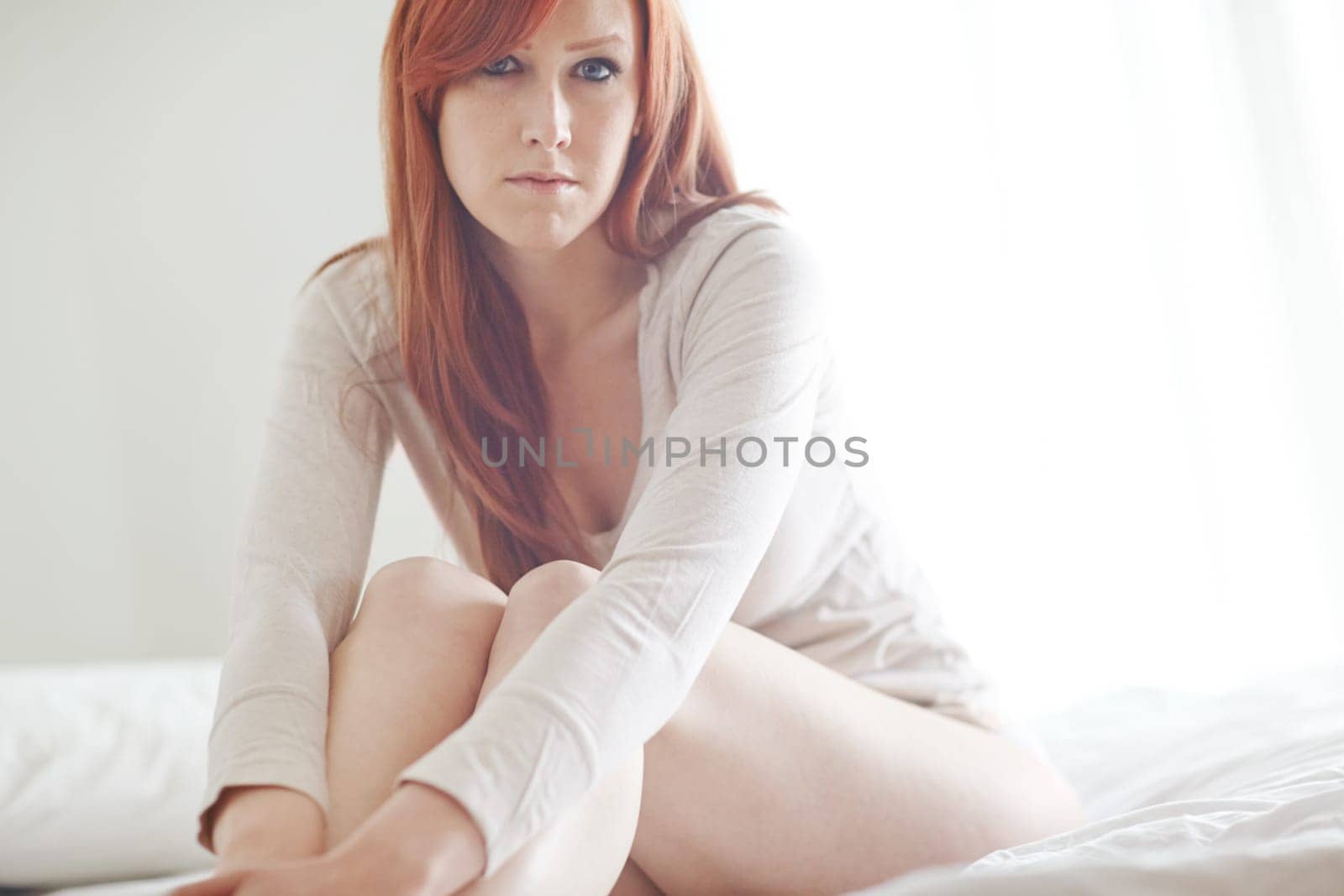 Portrait, woman and sitting on bed for relax with morning, casual weekend and natural light in home. Ginger model girl, rest and free time in bedroom with bedding, wellness and peace in apartment by YuriArcurs