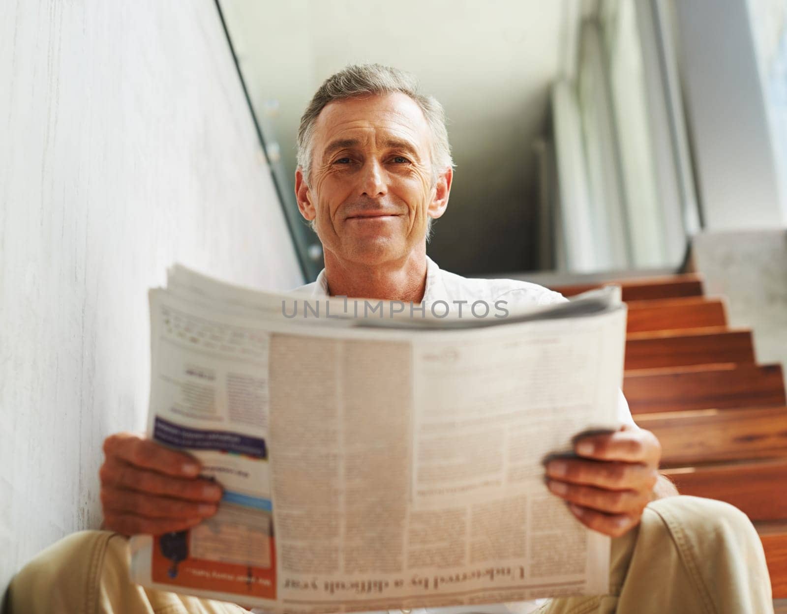 Mature, man and portrait smile with newspaper for journalist report or press information, global or reading. Male person, face and home stairs for feedback review with relax, morning or apartment.