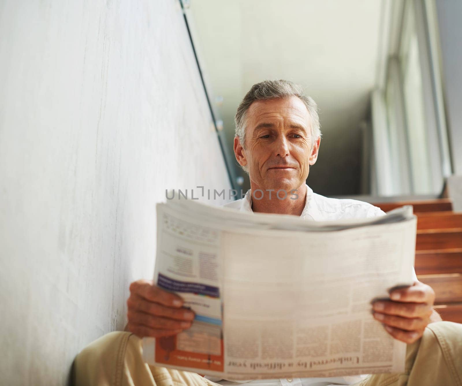 Mature, man and newspaper reading in office for stock market review for news article, journalist or investment. Male person, face and business section on stairs with global financial, report or press.