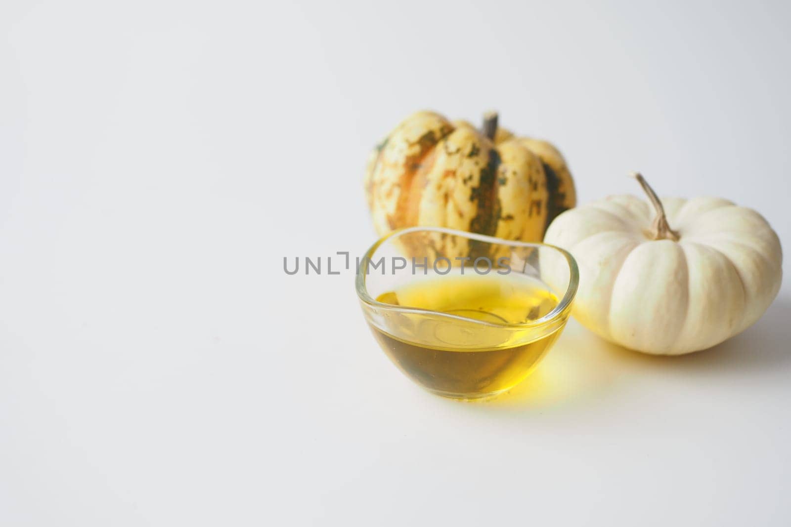 Pumpkin seed oil in glass on white background
