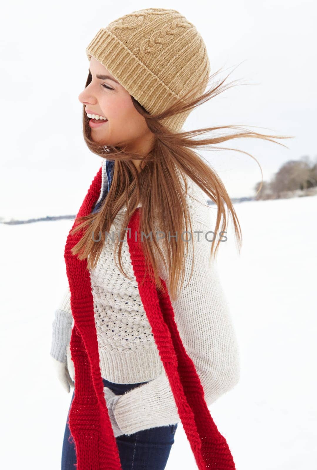 Laughing, snow and happy woman in winter with scarf, beanie or jersey in Sweden on holiday vacation. Female person, smile or girl walking on outdoor trip for travel, adventure or wellness in nature by YuriArcurs