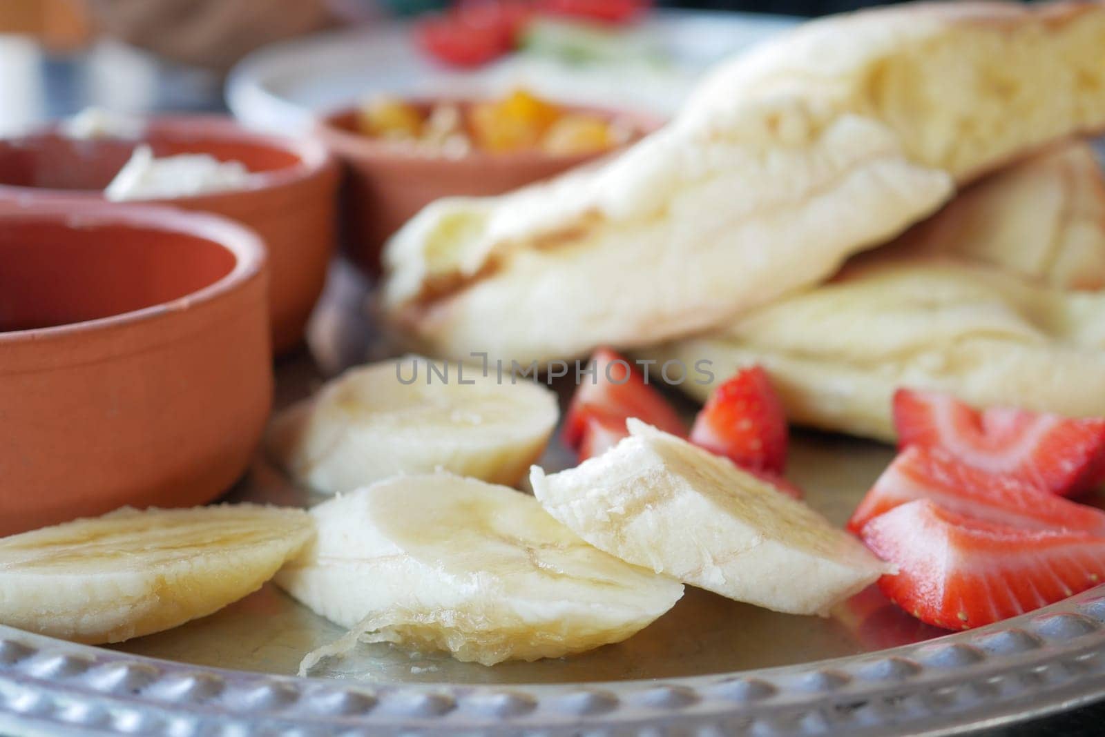 close up of slice of banana, strawberry and bread on table .