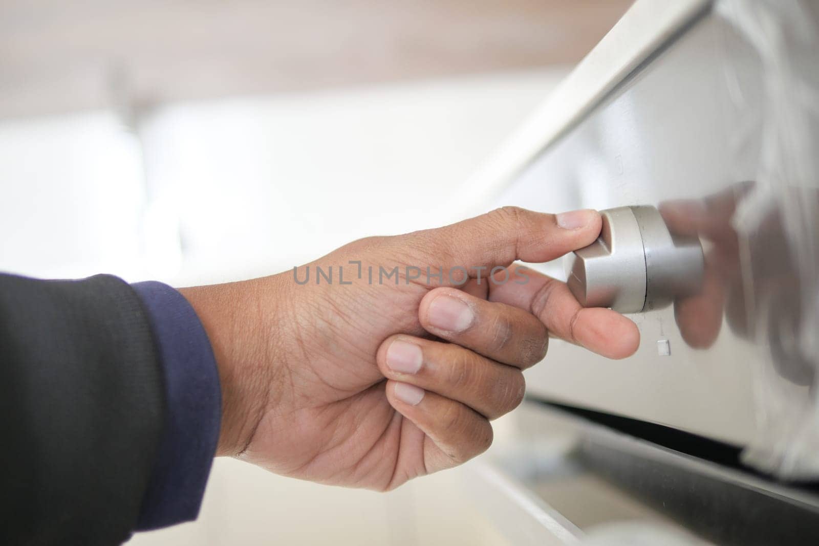 Close up of men hand setting temperature control on oven