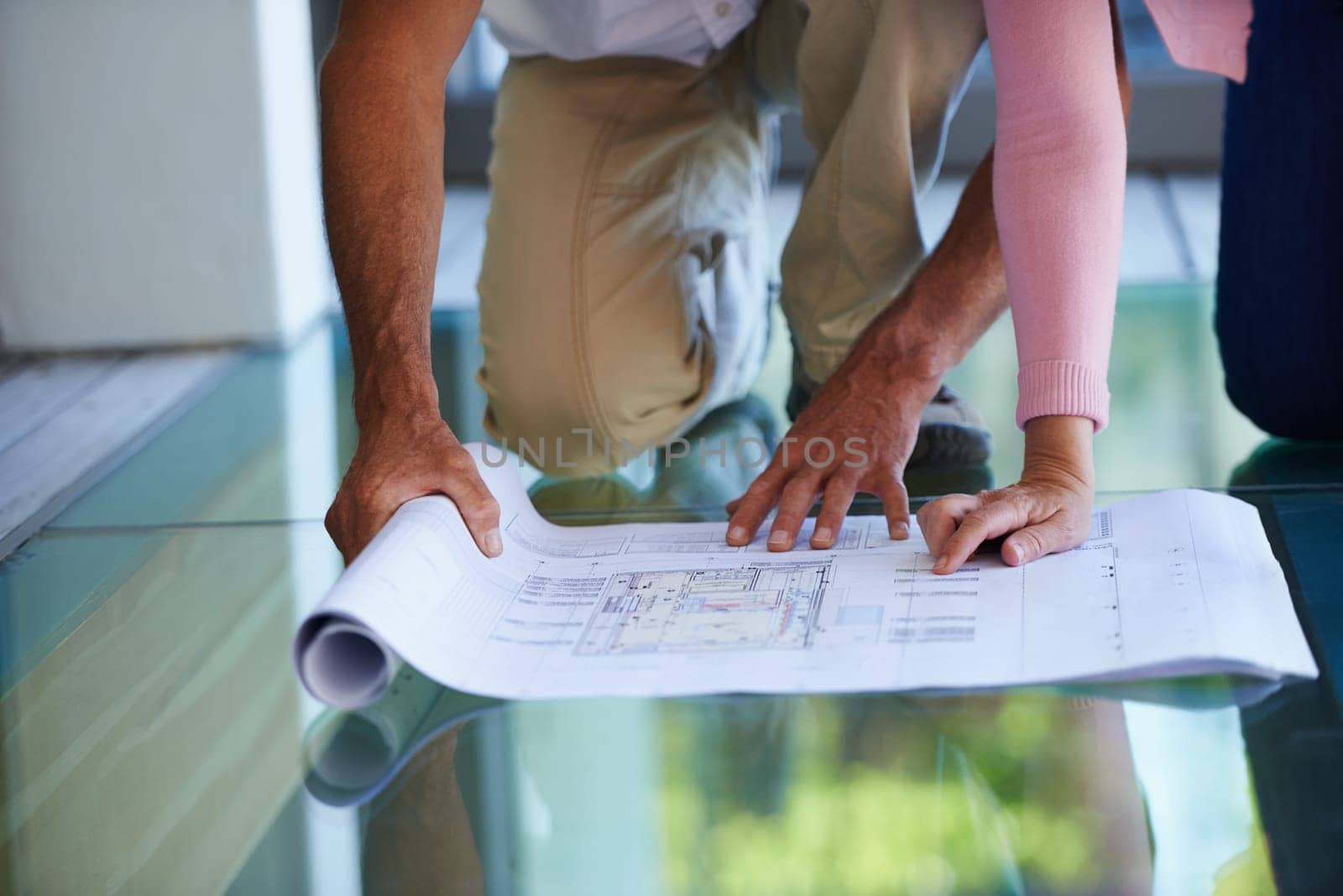 People, hands and planning with blueprint for interior design, maintenance or renovation at house. Closeup of contractor or building team with paperwork, document or floor layout for home improvement.