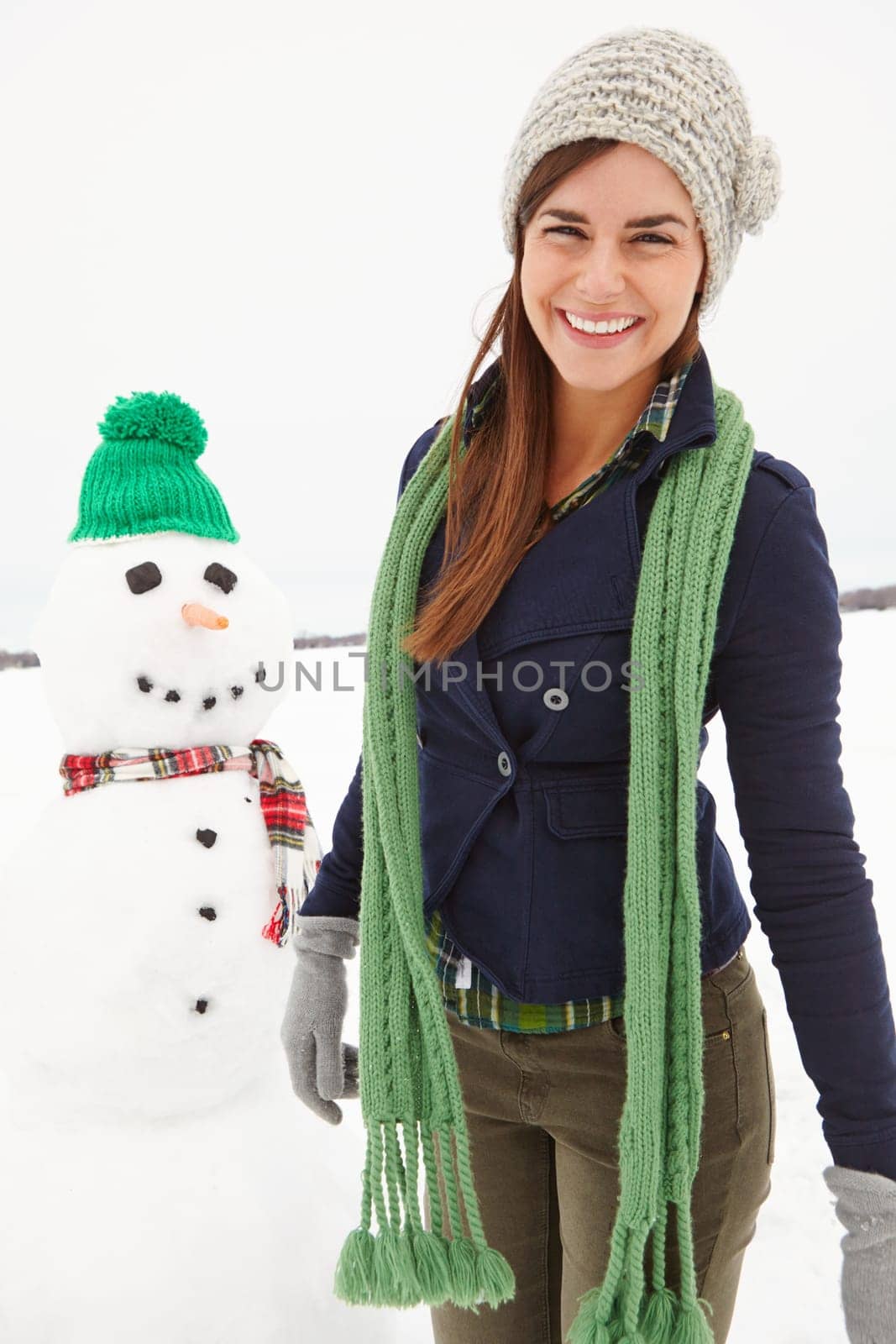 Woman, snowman and happy in portrait on vacation in nature with clothes for adventure in cold. Person, ice character and outdoor with smile for playful creativity in countryside for holiday