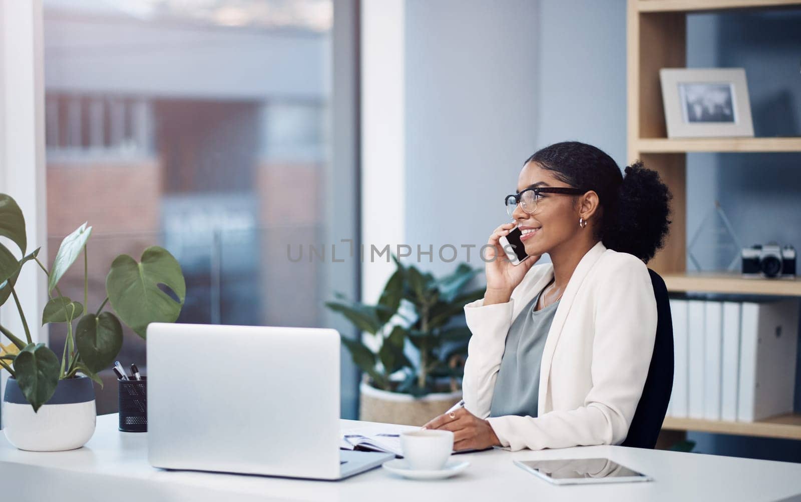 Phone call, laptop and black woman in office for online talking, networking and discussion. Corporate worker, consulting and person on smartphone and computer for planning, contact or communication.