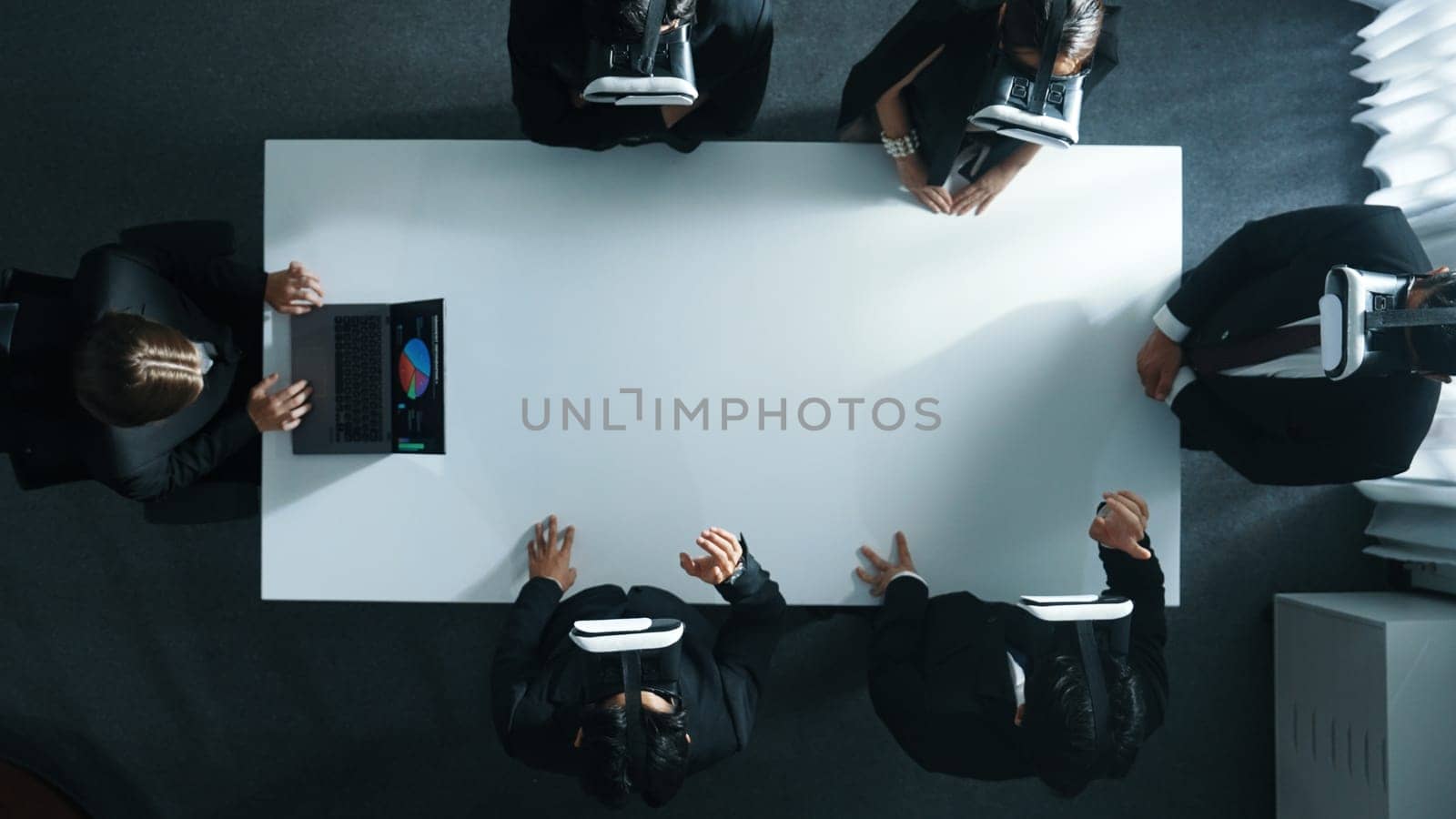 Top down aerial view of professional business team wear vr headset to enter virtual world while sitting and using hand gestures to manipulate the data from the manager laptop. Technology. Directorate.