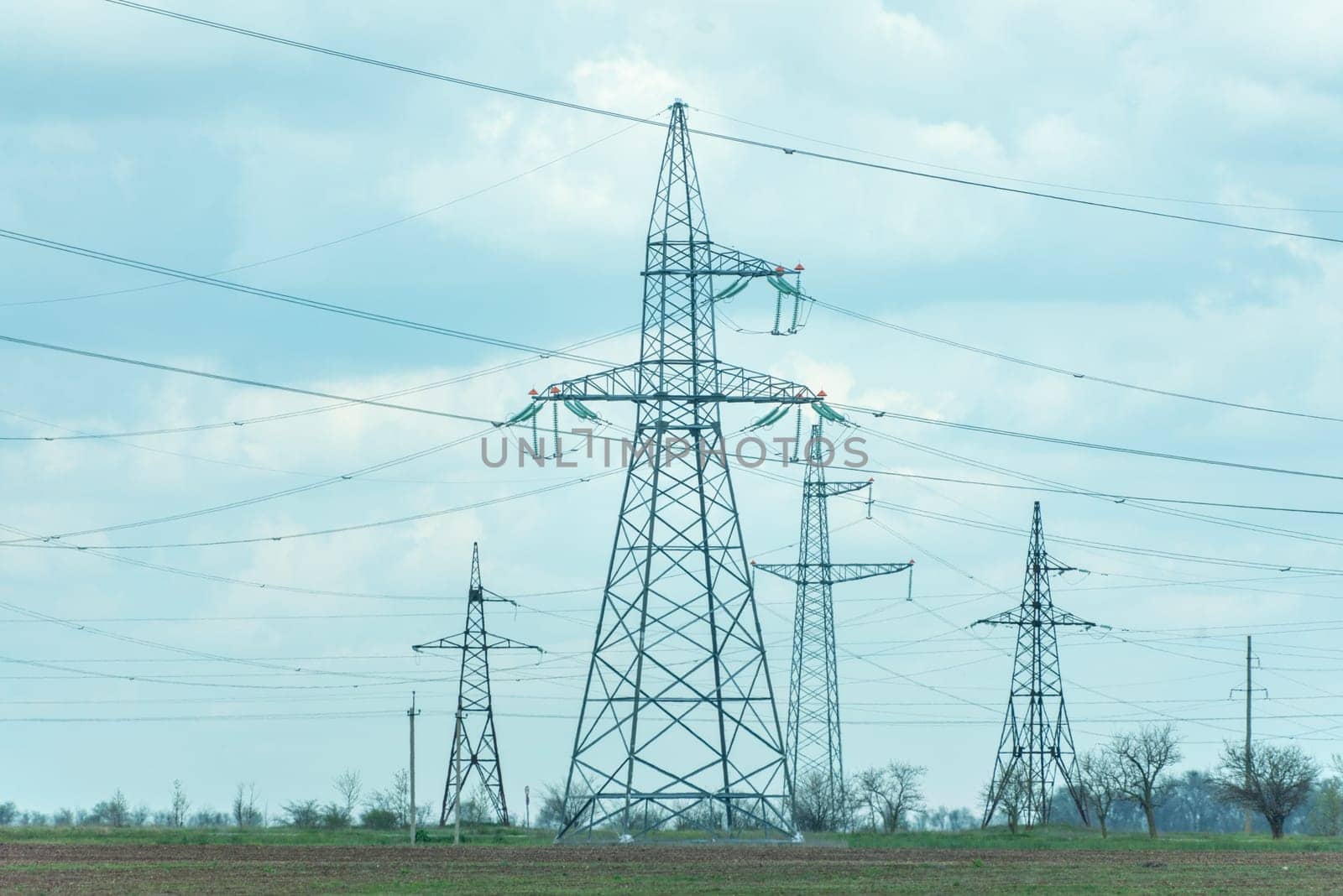 High voltage towers with sky background. Power line support with wires for electricity transmission. High voltage grid tower with wire cable at distribution station. Energy industry, energy saving.