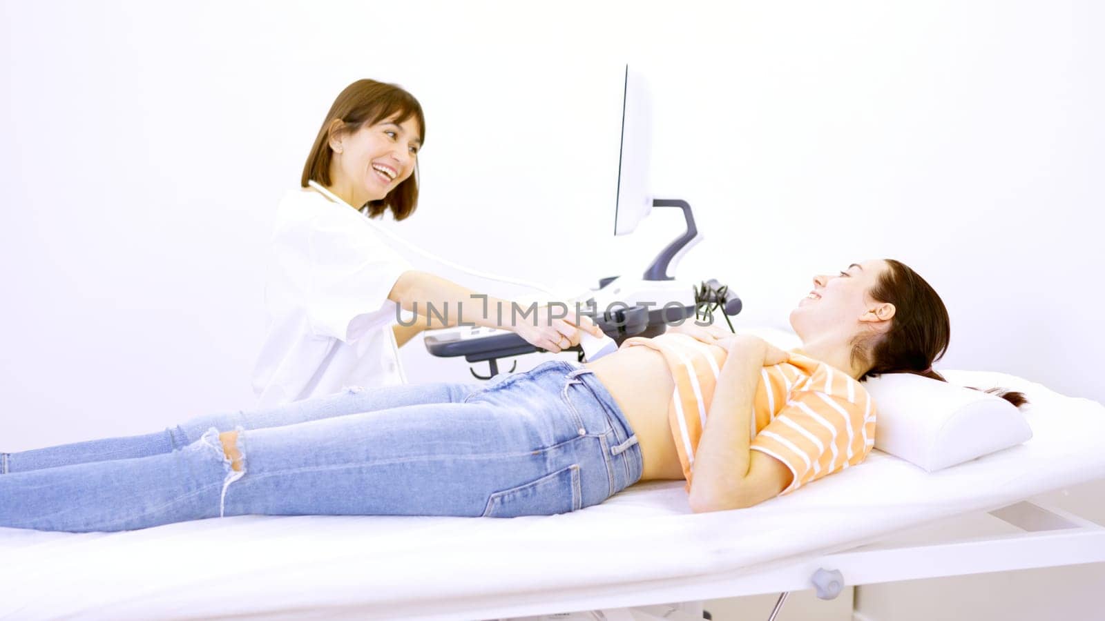 Doctor informs a patient that she is pregnant during ultrasound by ivanmoreno