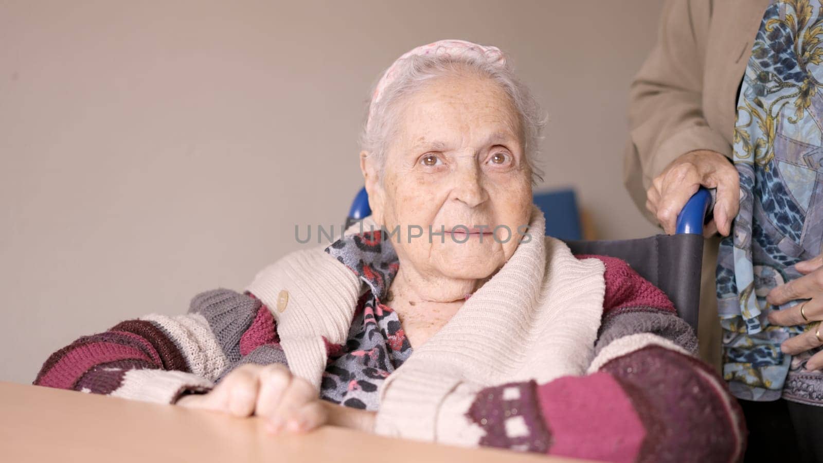 Senior woman looking at camera sitting in wheelchair by ivanmoreno