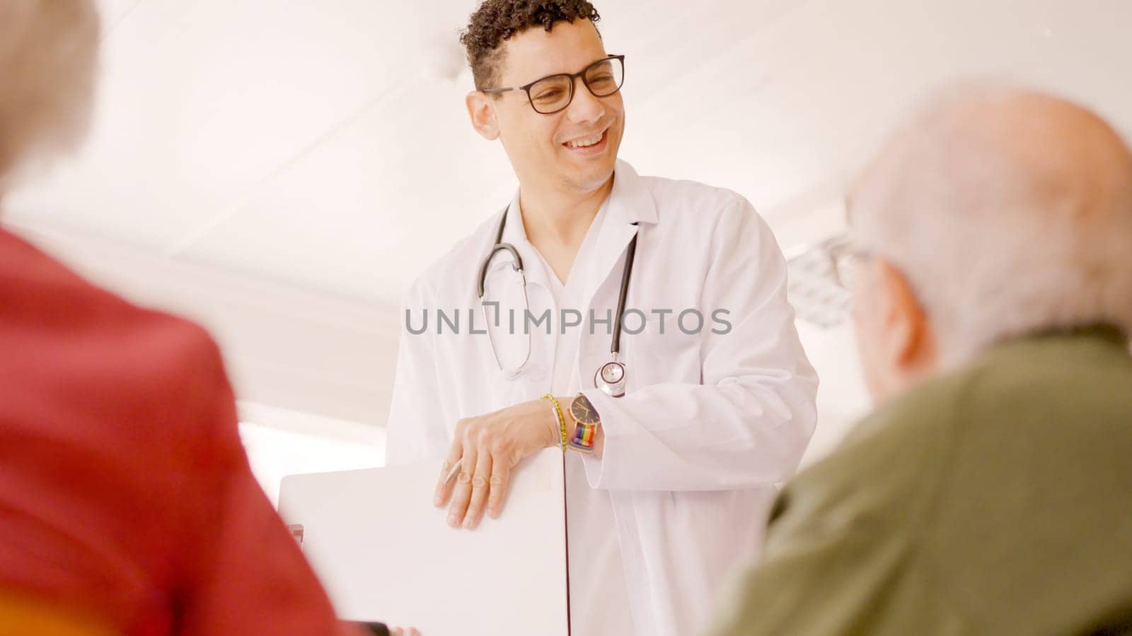 Gay doctor writing data in a medical report of senior people by ivanmoreno