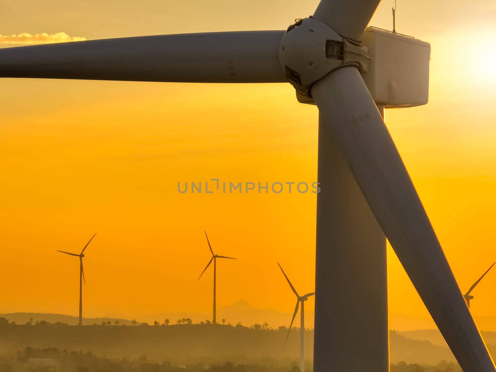 Wind farm field and sunset sky. Wind power. Sustainable, renewable energy. Wind turbines generate electricity. Sustainable development. Green technology for energy sustainability. Eco-friendly energy.