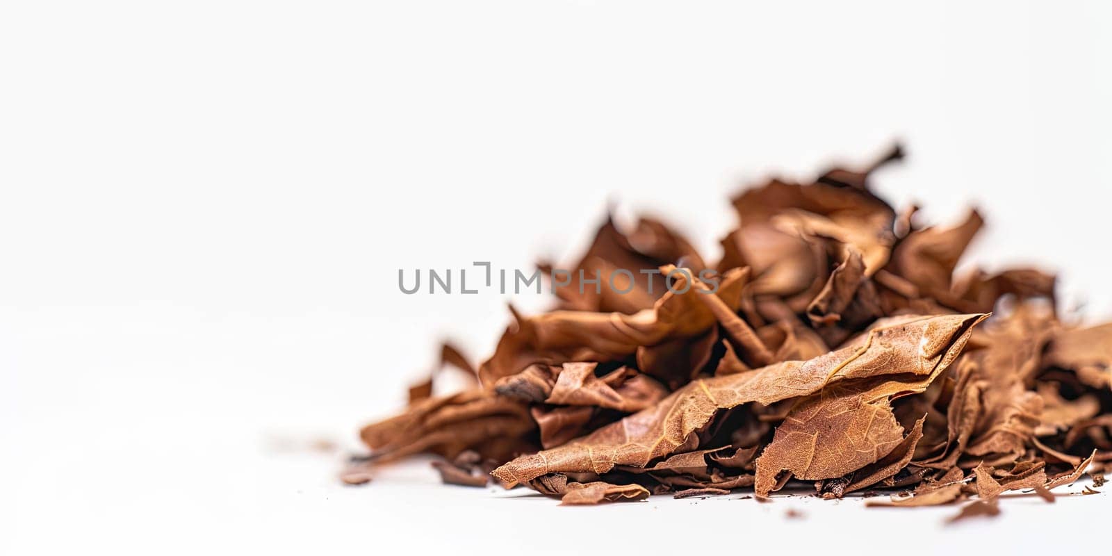 Dried tobacco leaves pile with shallow depth of field on white background with empty space for text. Depicting raw material for cigarettes and cigars. Ai generation. by Lunnica