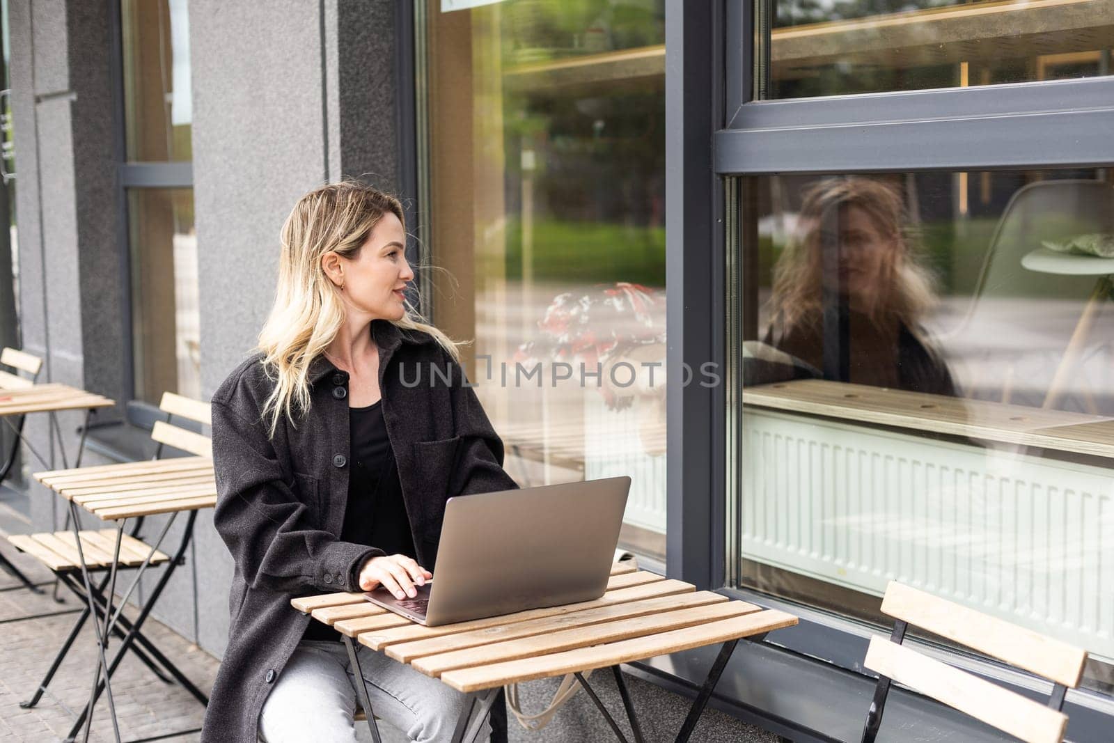 Young woman working at a remote job in a cafe. High quality photo