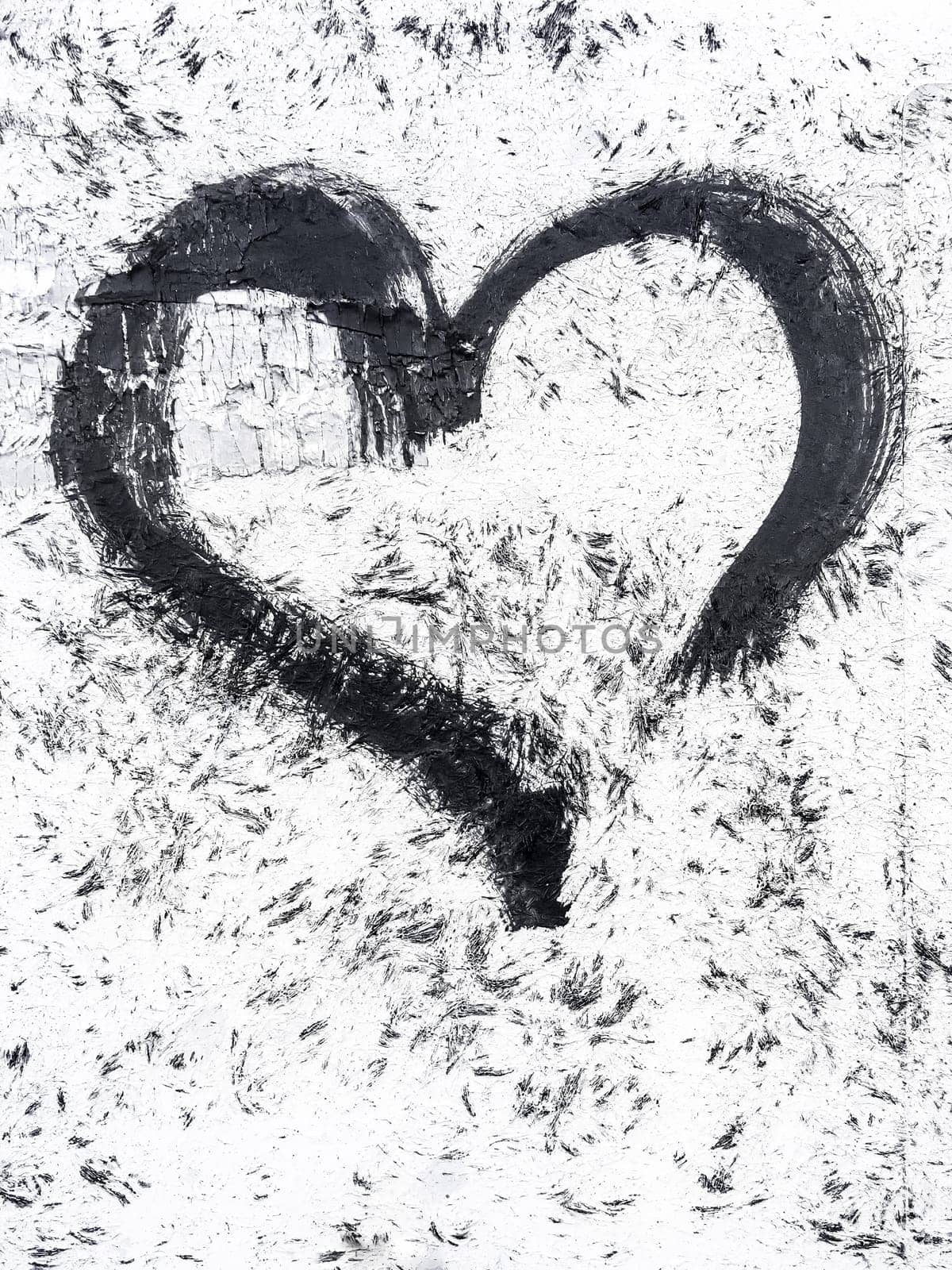 Black heart on white wall. Ideal for texture, background or concepts.
