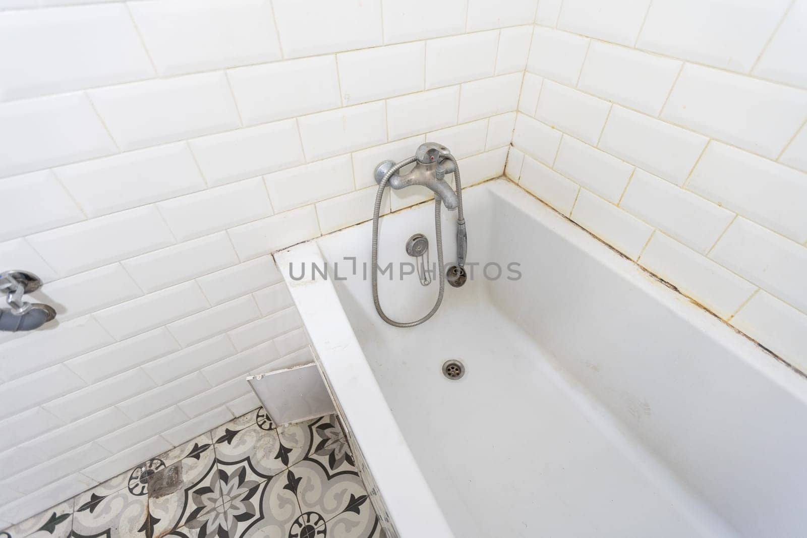 Interior of narrow restroom with wall hung toilet with white walls and checkered floor. High quality photo