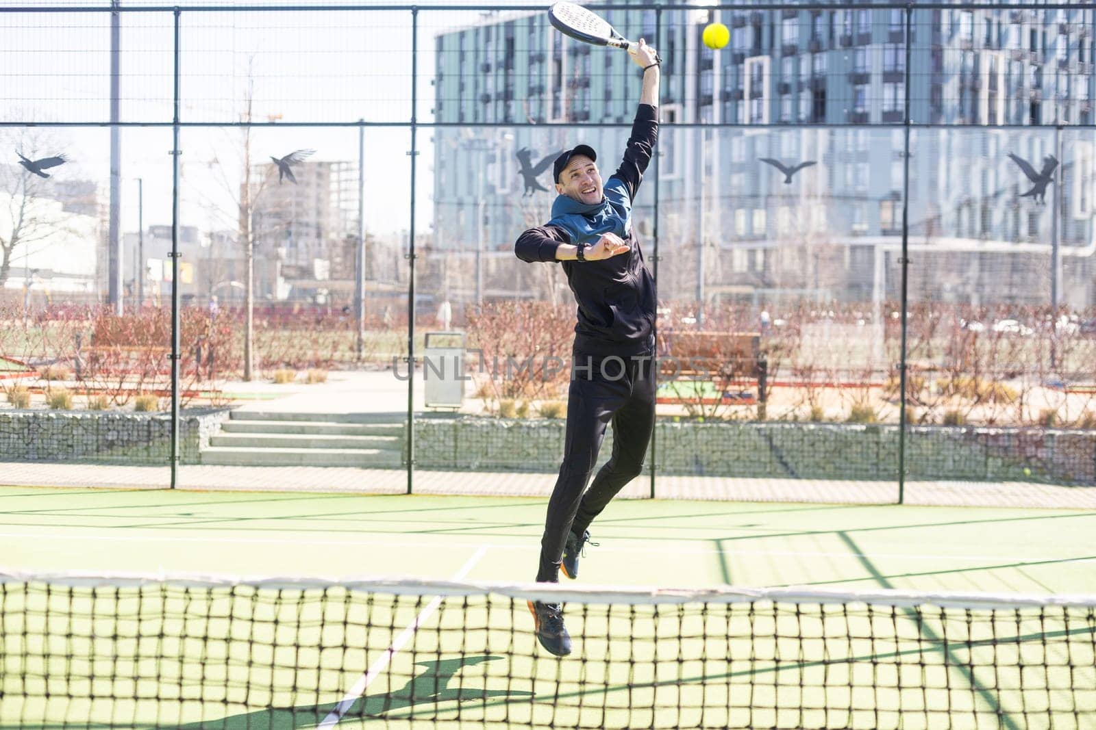 Paddle tennis player serving training with her couple in court. High quality photo