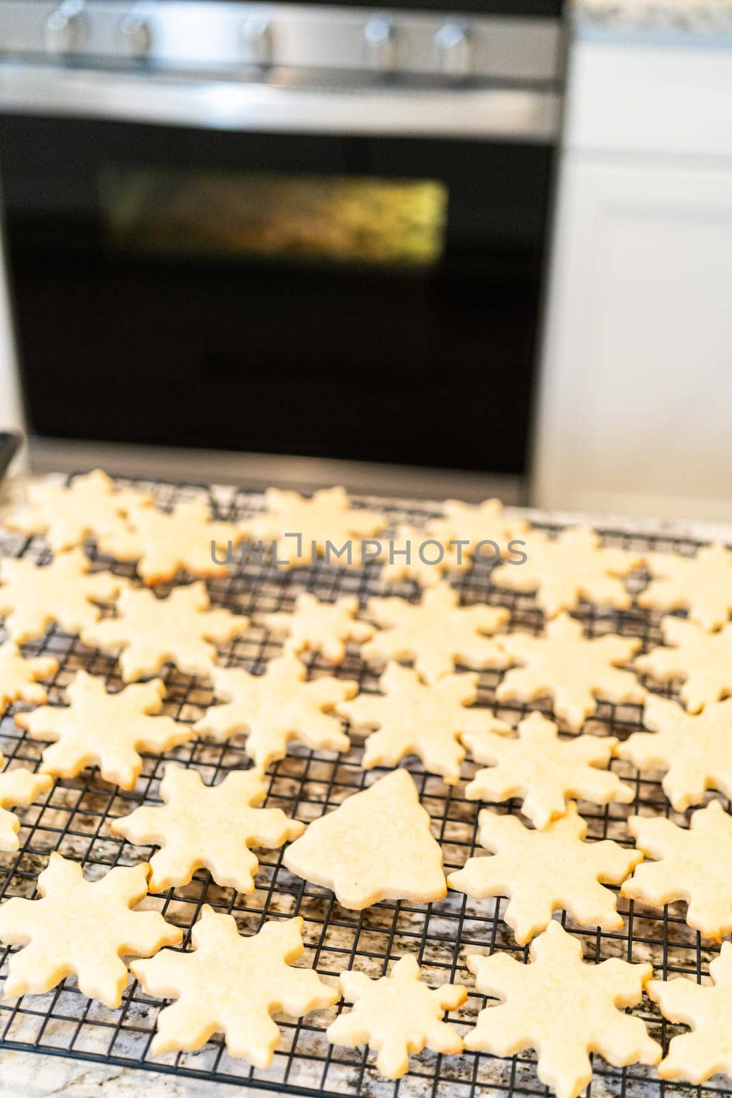 Cooling Snowflake-Shaped Sugar Cookies on a Rack by arinahabich