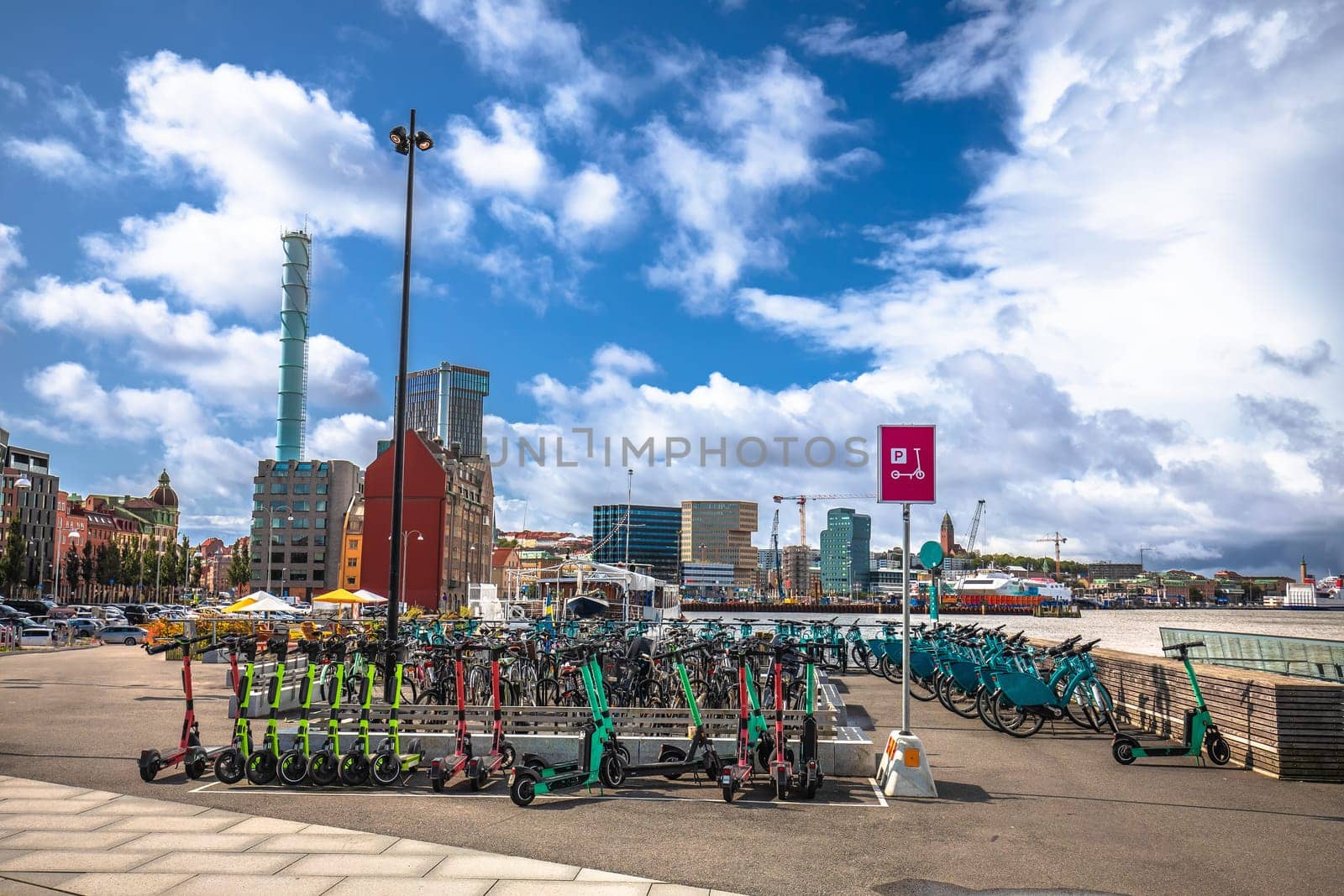 Electric scooter and bicycle hub in Gothenburg harbor view, green transportation in Sweden