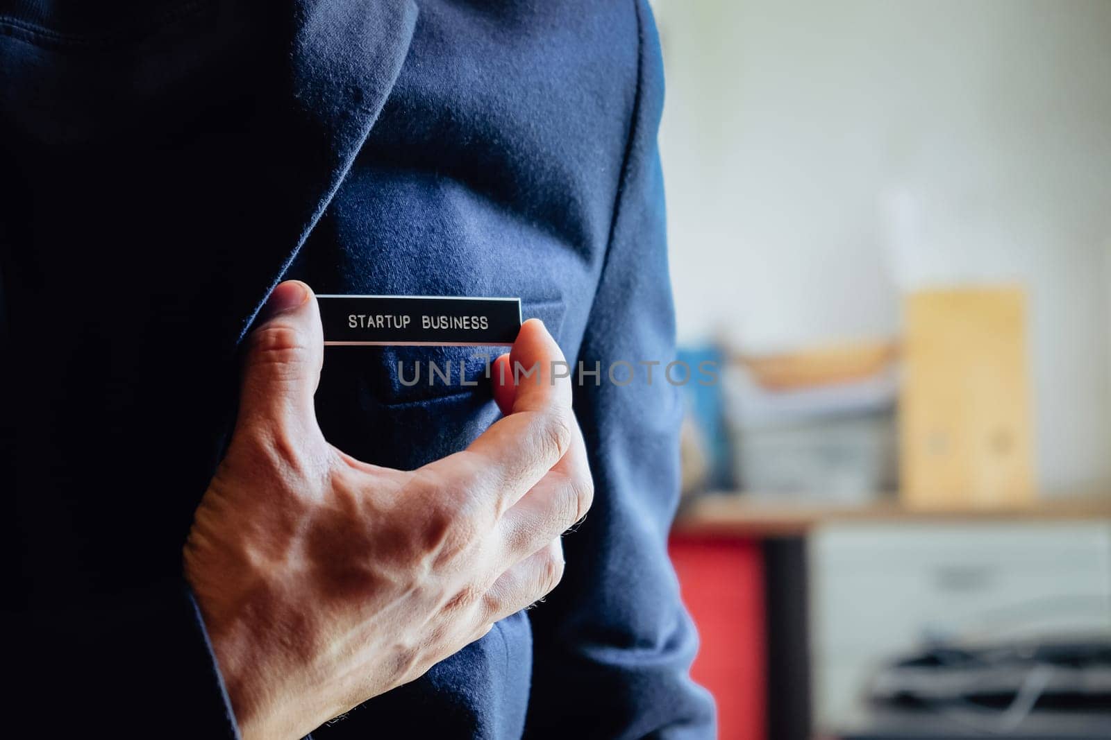 businessman holding a startup business label in his hand, business concept