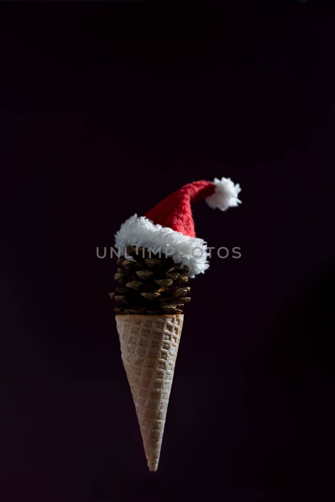 A cone shaped ice cream cone with a red hat on top. The cone is made of pine cones and the hat is made of white and red fabric. by Matiunina