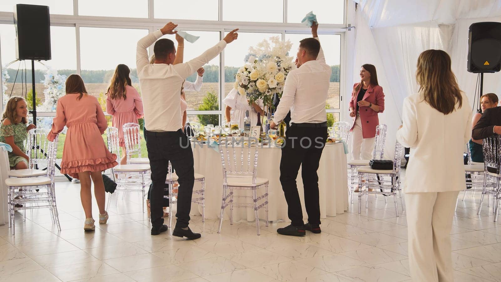 Lida, Belarus - August 25, 2023: People dancing at the wedding day banquet. by DovidPro