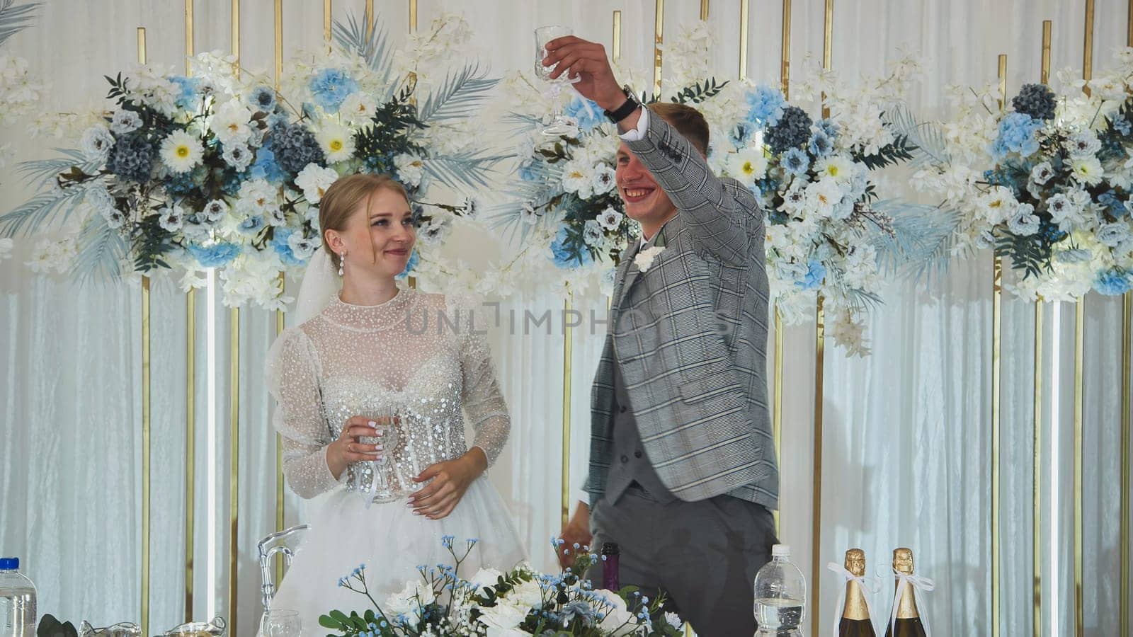 The bride and groom at the table at the banquet of their wedding. by DovidPro