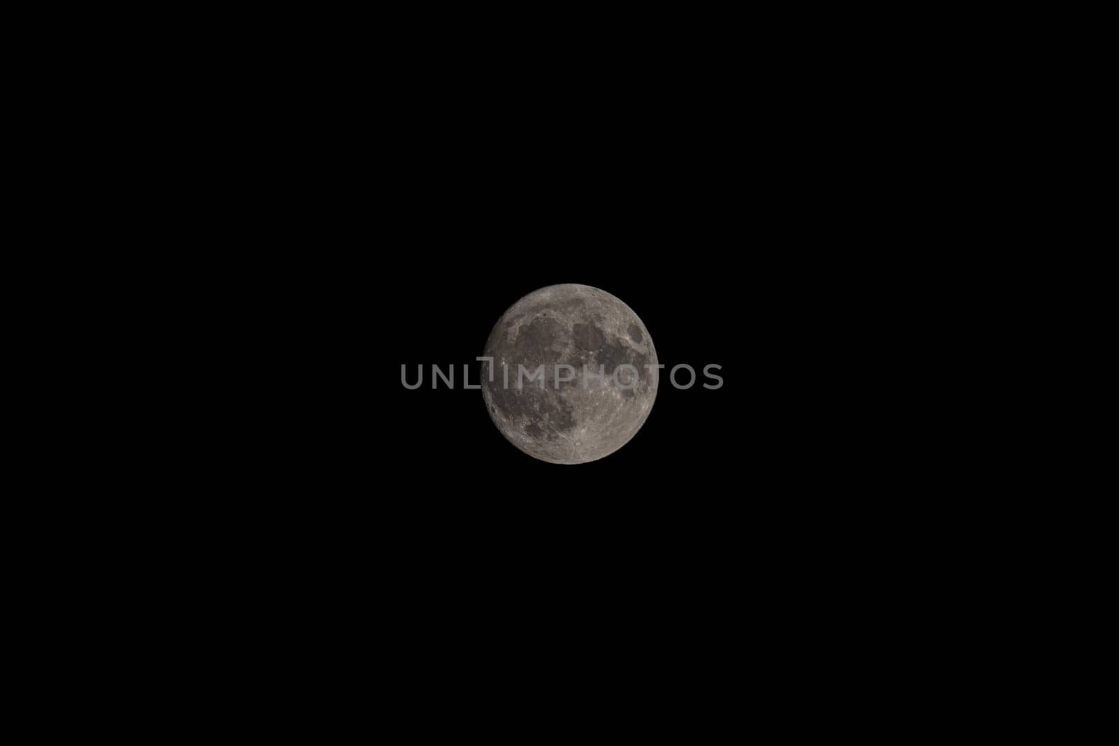 Moonlit Embrace: Telephoto Reverie in Nocturnal Stillness.Immerse yourself in the ethereal beauty of the almost full moon, captured with stunning detail amidst the tranquil night