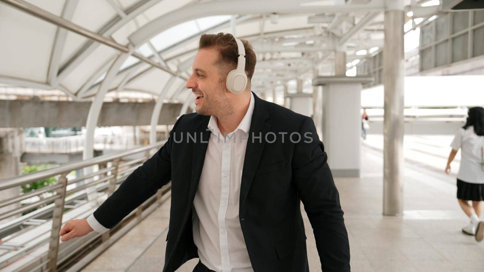 Happy business man dancing while wear headphone at bridge in urban city. Urbane. by biancoblue
