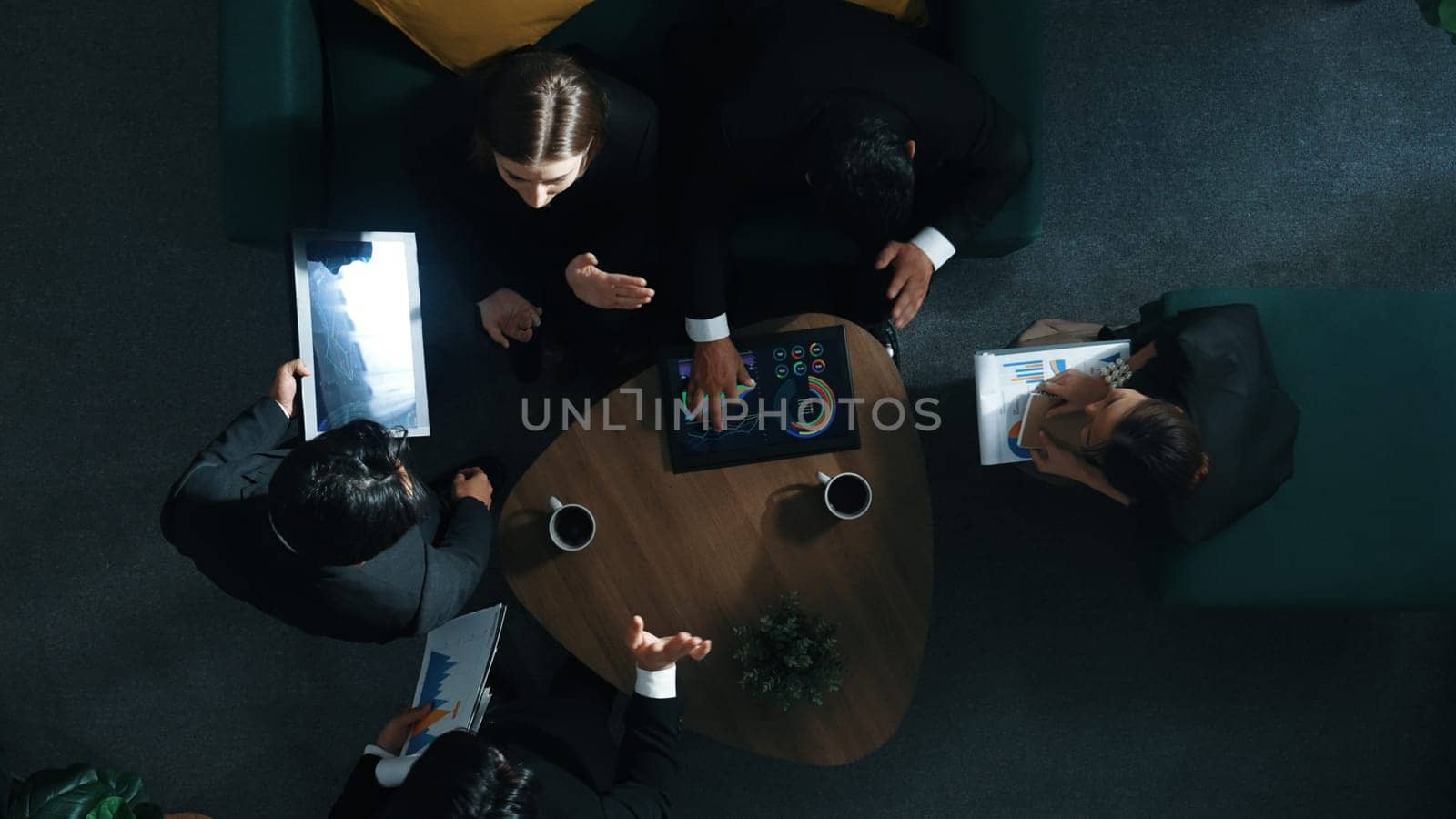 Top down aerial view of team analysis financial graph while female leader join meeting and present stock market investment chart. Smart manager listen presentation while asking question. Directorate.
