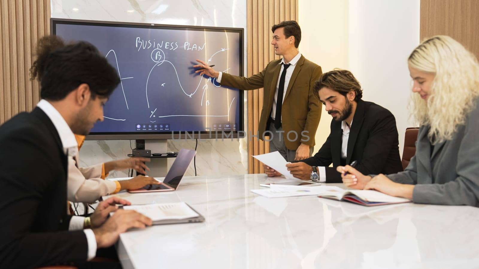 Presentation in ornamented meeting room with business professionals attending to project development drafting plan. Conference meeting with CEO present plan for investor and colleague with new project