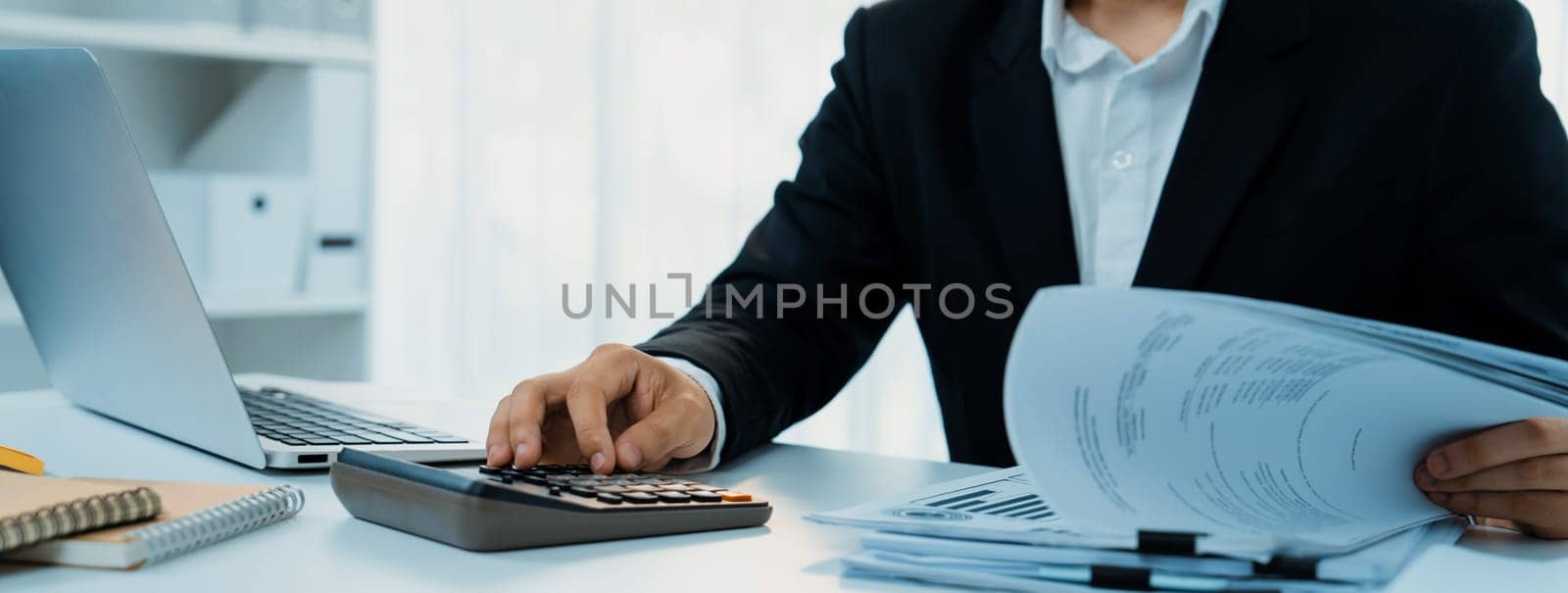 Corporate accountant use calculator to calculate and maximize tax refunds and improve financial performance based on financial data report. Modern business accounting in panorama. Shrewd