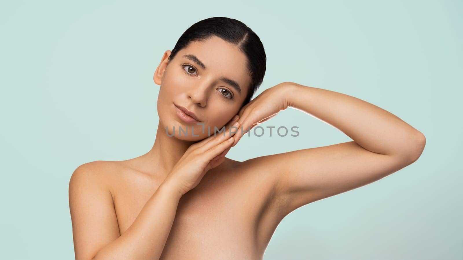 Glamorous natural beauty headshot portrait of a beautiful multiracial Turkish woman with perfect moisturized healthy skin and charming smile naked shoulders.
