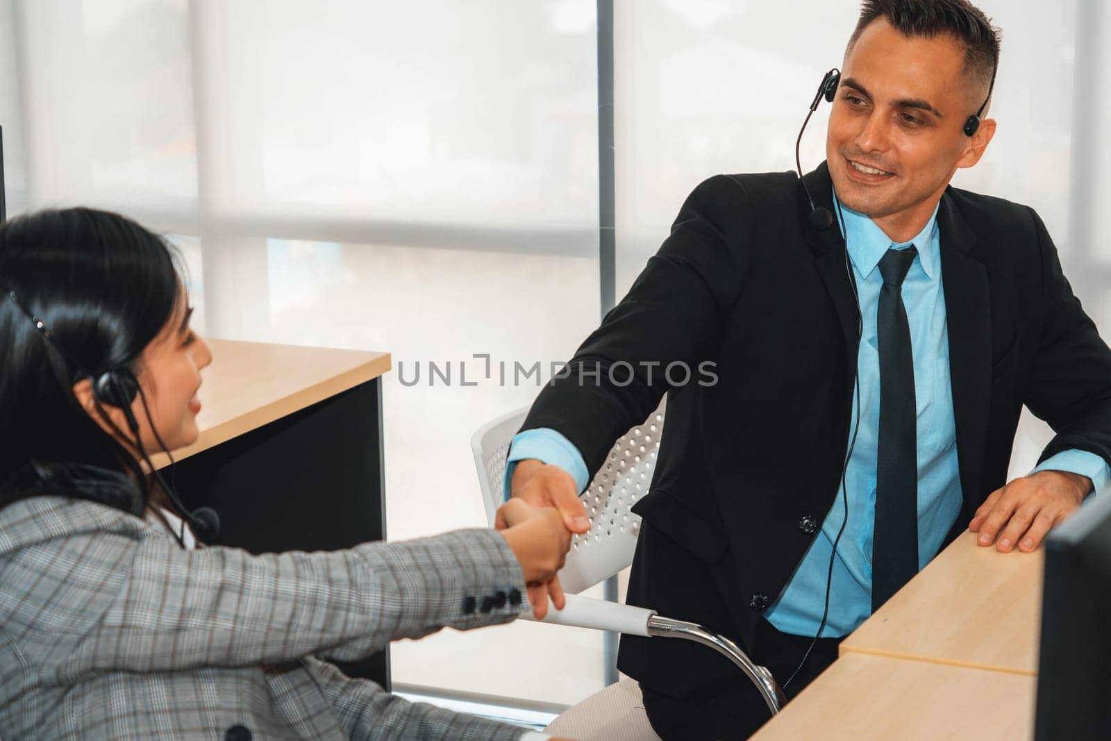 Business people wearing headset celebrate working in office . Call center, telemarketing, customer support agent provide service on telephone video conference call. Jivy