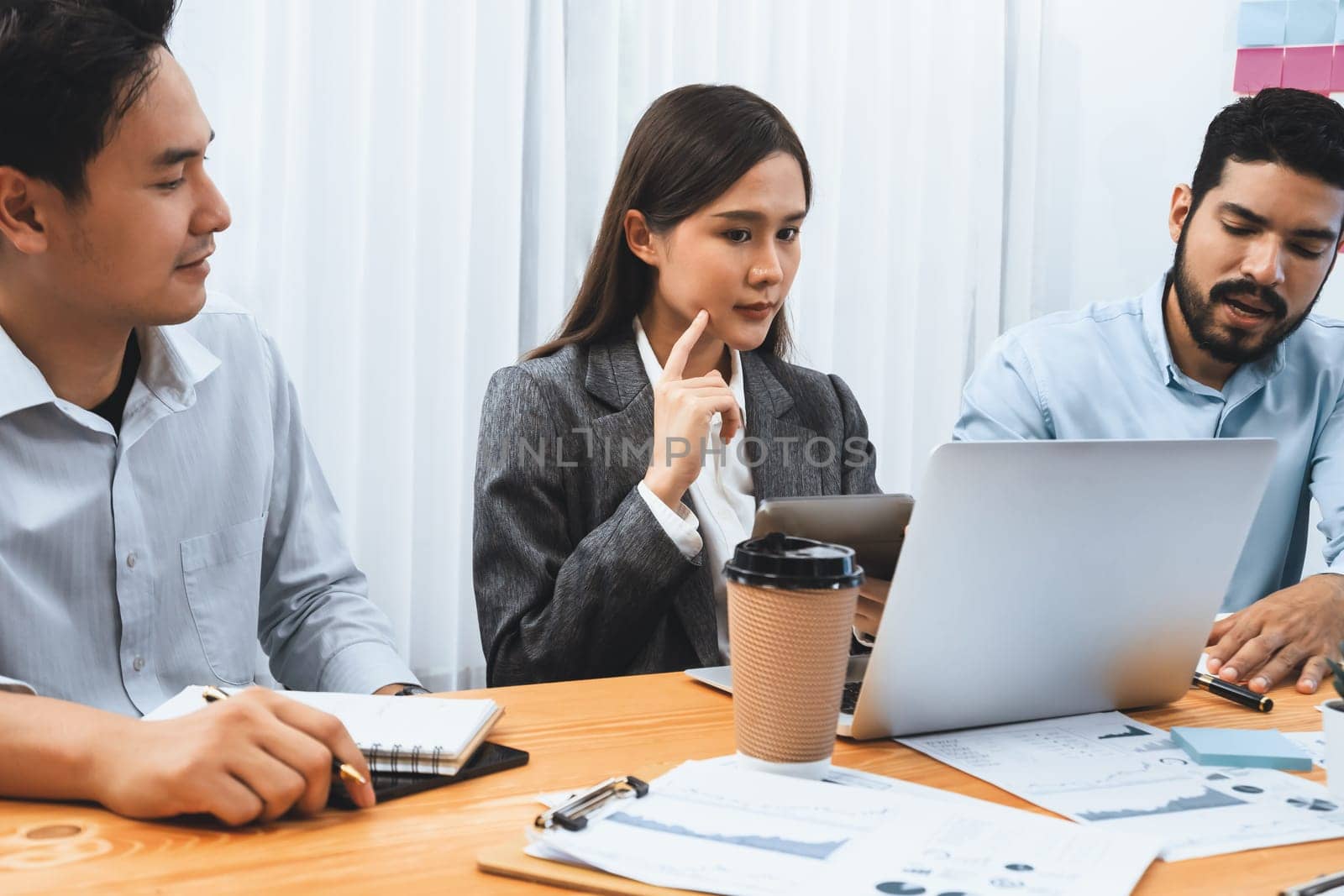 Multiracial analyst team use BI dashboard data to analyze financial report on meeting table. Group of diverse business people utilize data analysis by FIntech for success business marketing. Concord