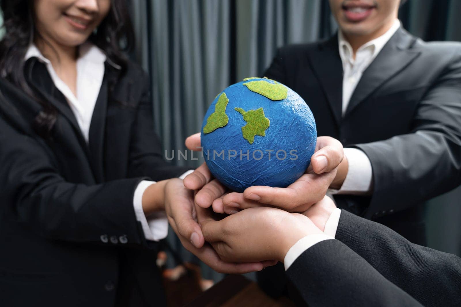 Top view business people holding Earth together in synergy as team building to utilize eco regulation for environmental protection by reducing CO2 emission to save Earth. Quaint