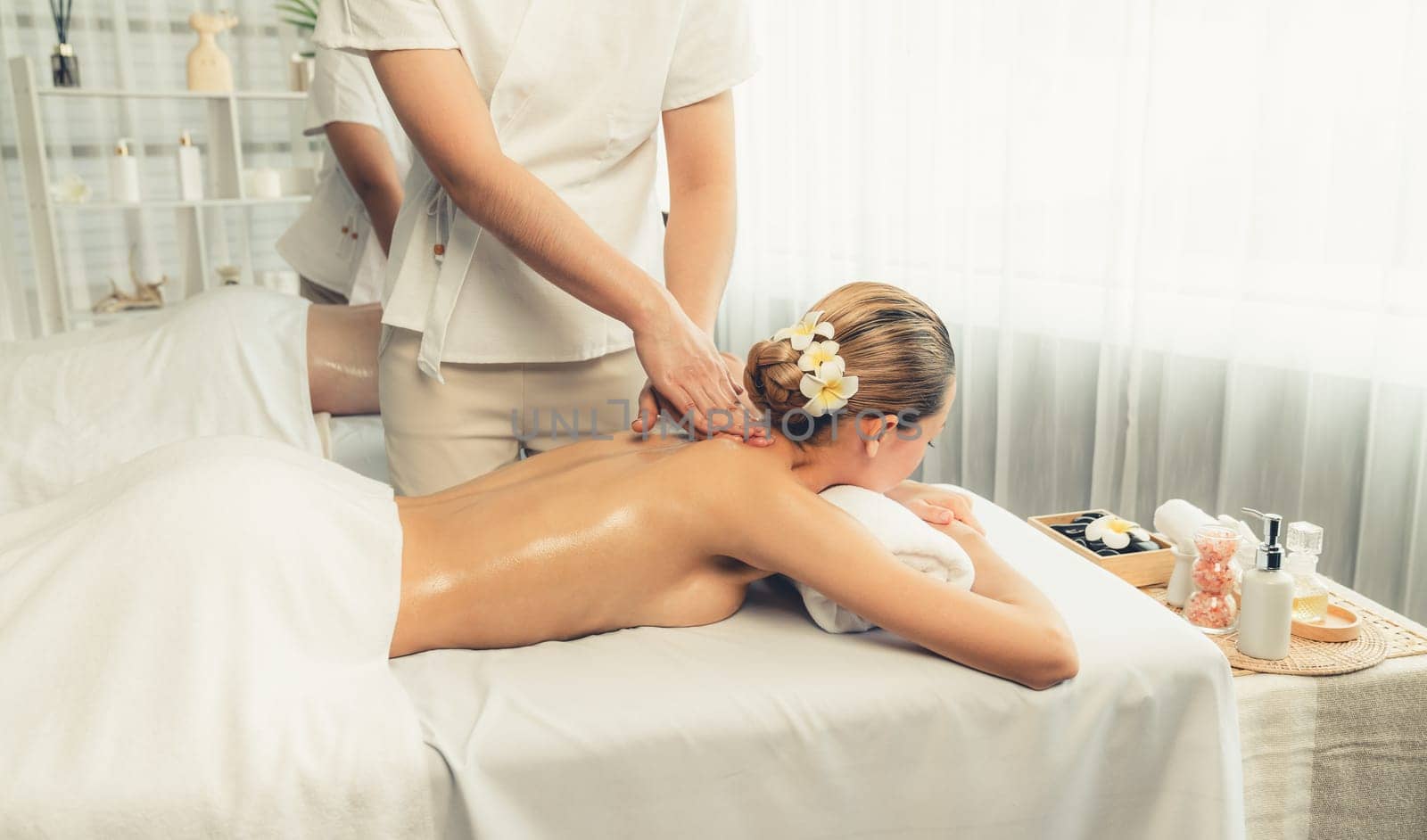 Caucasian woman customer enjoying relaxing anti-stress spa massage and pampering with beauty skin recreation leisure in day light ambient salon spa at luxury resort or hotel. Quiescent