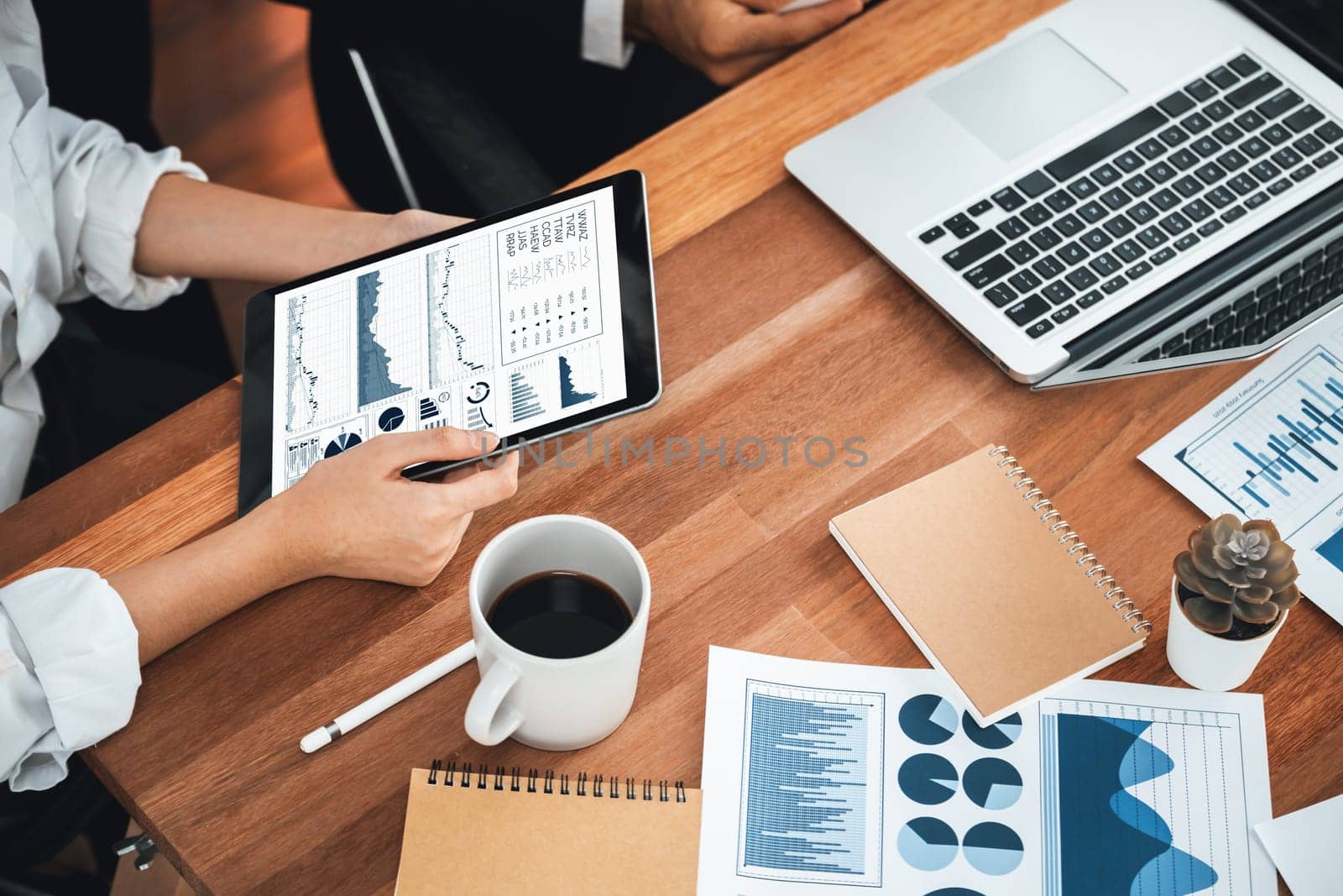 Diverse group of business analyst team analyzing financial data report paper on office table. Chart and graph dashboard by business intelligence analysis for strategic marketing planning Meticulous