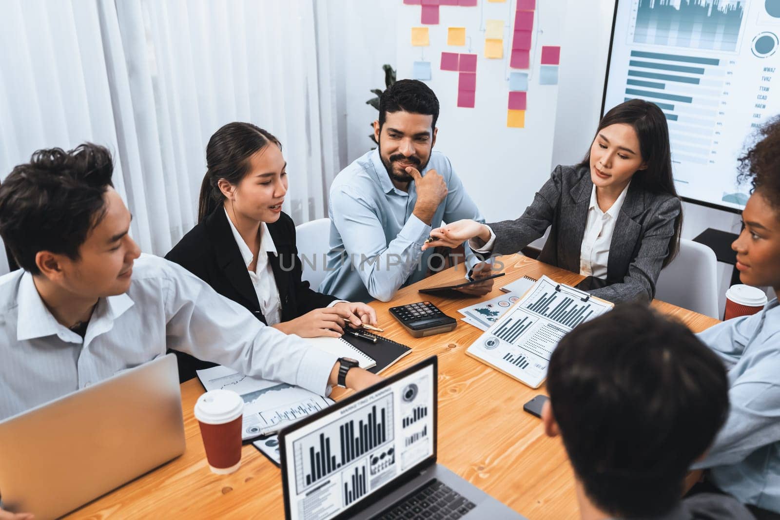 Multiracial analyst team use BI Fintech software to analyze financial data on meeting table. Financial dashboard data display on laptop screen with analyzed chart for marketing indication. Concord