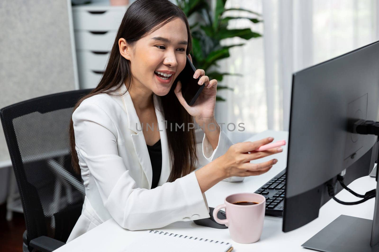 Working young Asian businesswoman calling to customer to present marketing online strategy advertisements analysis service to analyze on social website for planning channel sales target. Stratagem.