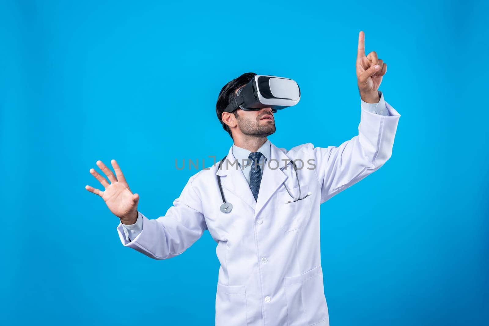 Caucasian doctor pointing and choosing medical data while standing. Handsome doctor wearing lab coat and VR goggles to connect metaverse or visual reality program. Technology innovation. Deviation.