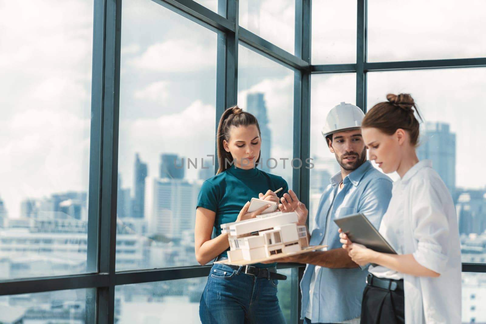 Smart engineer holds house model and explain about house construction to skilled manager. Group of interior designer inspect architectural model. Working together, Civil engineering. Tracery.